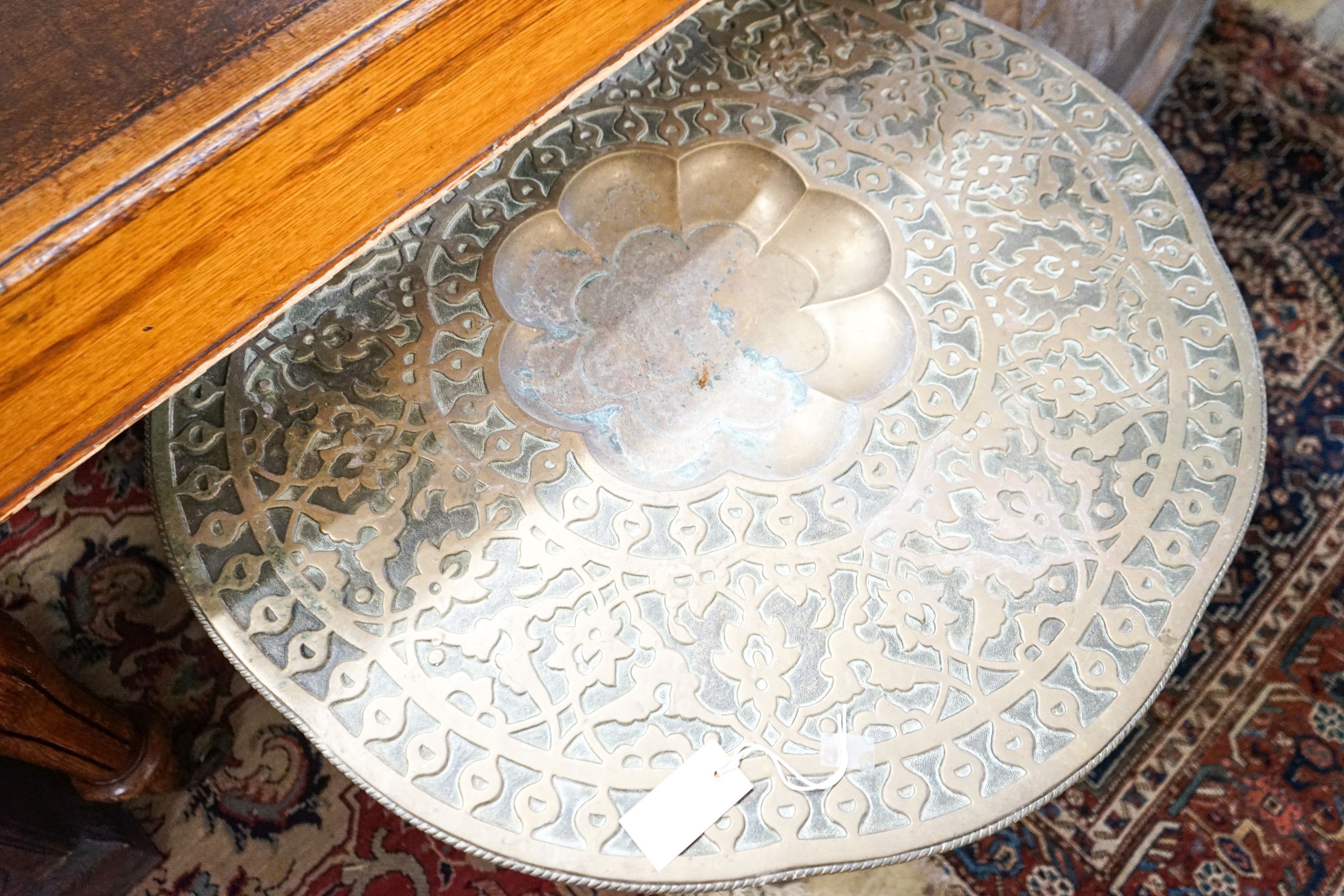 An Indian brass tray top table on folding stand, diameter 74cm, height 56cm together with a circular Indian brass tray